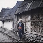 Носач Jean Brunhes-а и Auguste Léon-а позира испред куће, Вишеград, 25. октобар 1912. (фото www.albert-kahn.hauts-de-seine.fr)